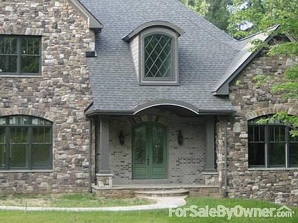 Detail of the Charming Front Porch
						:
						Front features arched, diamond-paned dormer window