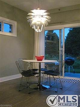 Dinette space with sliding glass door to outdoor patio space with great views. Beautiful designer Artichoke light fixture gives a modern dimension to this space.