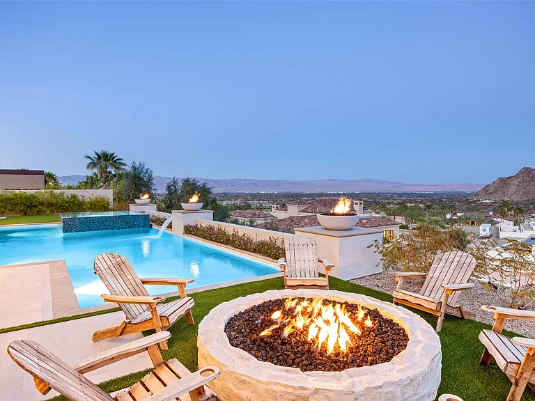 The property has it all: stunning views, cozy fire pit, and plenty of living spaces both indoors and outdoors.