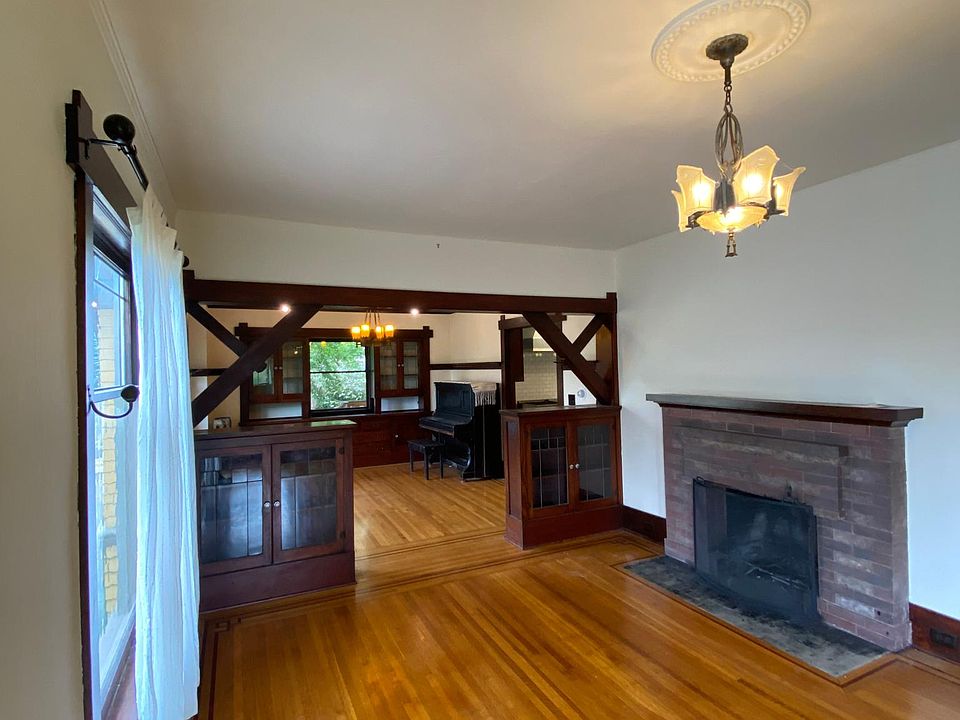 Large living room with working brick fireplace and built-in cabinets