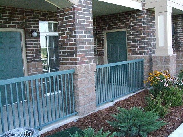 Front patio with furnace door (left) and large outdoor storage closet at the end.