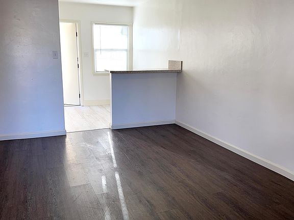 Living room and back door through kitchen breakfast bar area.