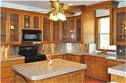 Stunning gourmet kitchen with granite countertops, custom cabinets and an island