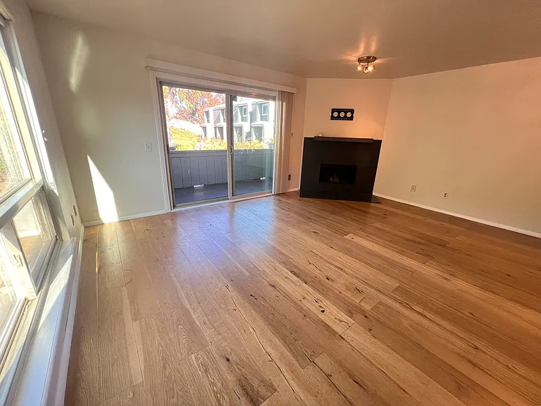 Living room with wood burning fireplace, 1 of 2 balconies and tons of natural light