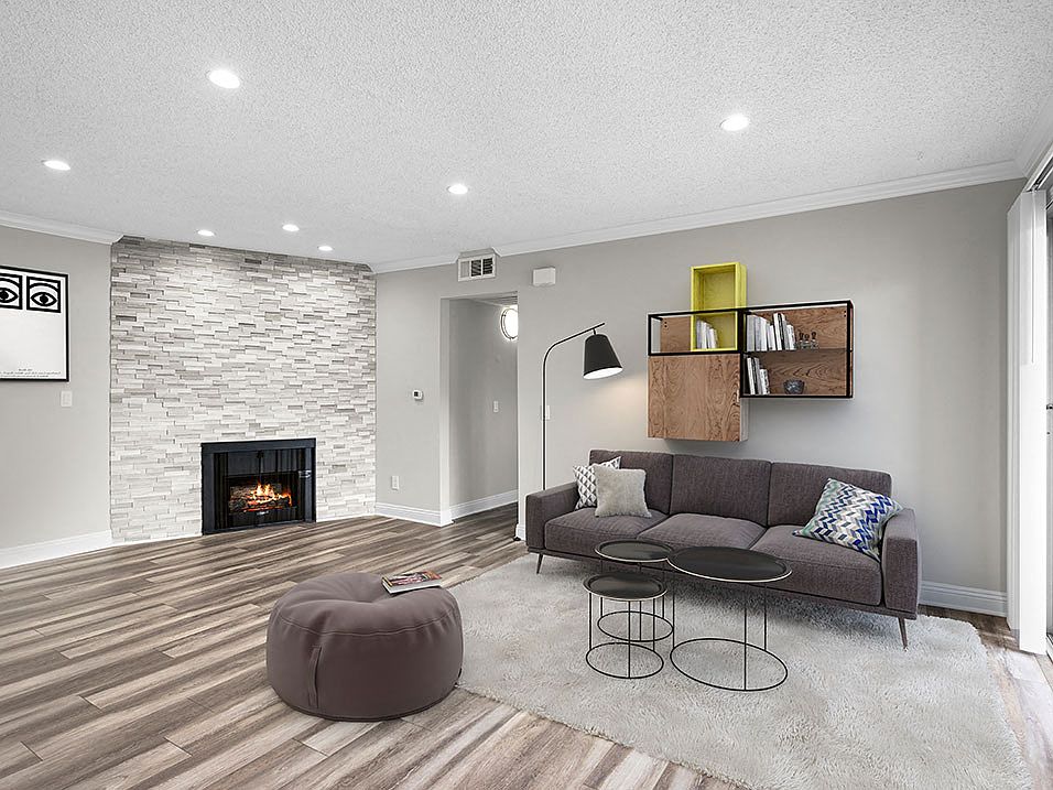 Living room with decorative stone wall, fireplace, and hardwood floors.
