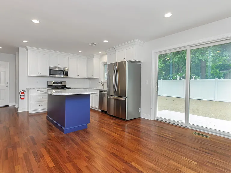 EAT-IN KITCHEN- SS appliances, granite counters, center island with breakfast bar plus recessed lighting- slider leads to rear yard and patio