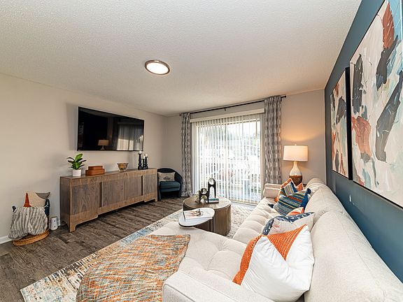 Spacious living room with hardwood-style flooring and overhead lighting