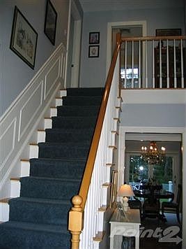 Stairway to 2nd level. Wainscoting, hardwood on stairs.