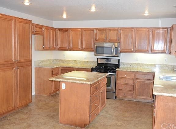 Large chefs kitchen with stainless steel appliances, island, granite, and so much prep space!