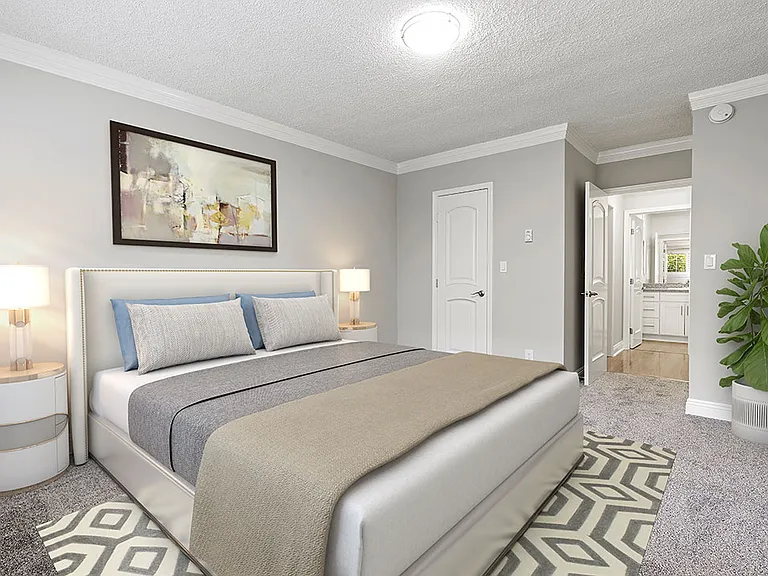 Well-lit carpeted bedroom with private bathroom.