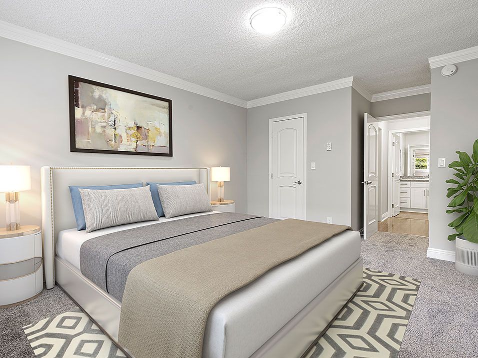 Well-lit carpeted bedroom with private bathroom.