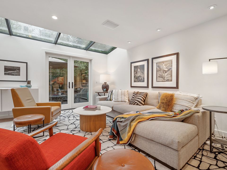 Open plan living room with skylights and doors to deck