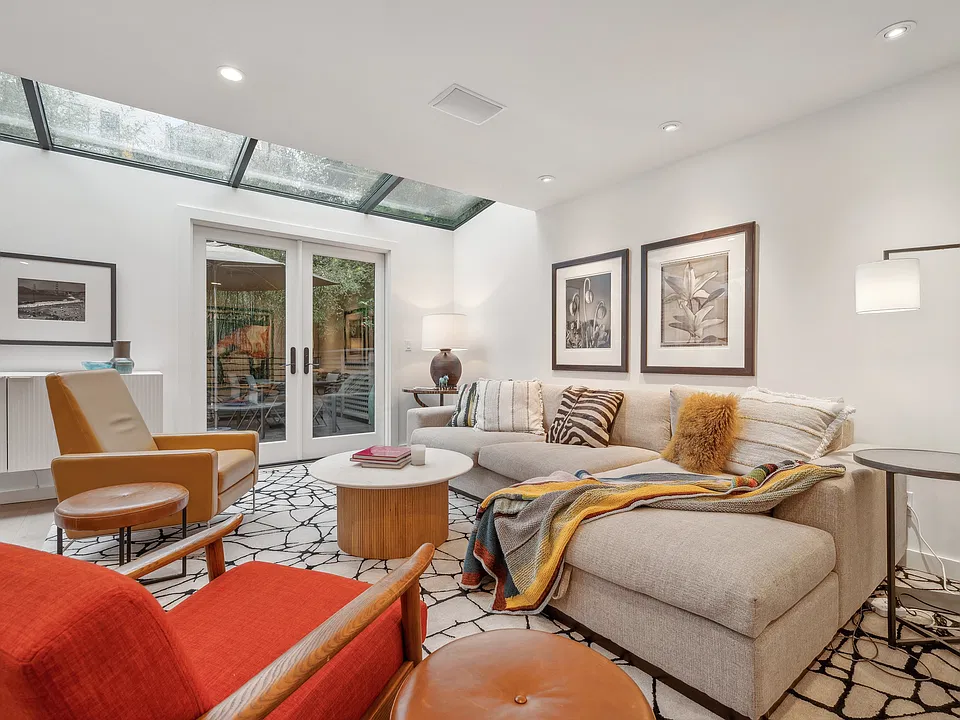 Open plan living room with skylights and doors to deck