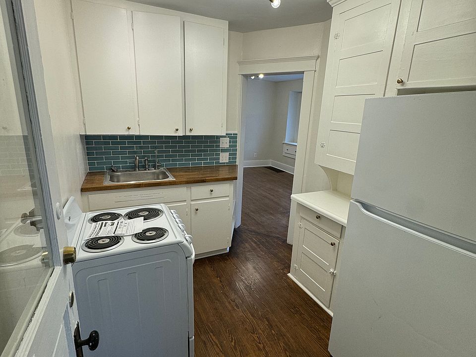 Updated kitchen with tile backsplash, butcher block countertops and new electric range + refrigerator.