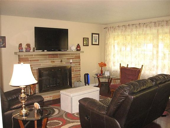 COZY LIVING ROOM WITH GAS FIREPLACE  AND LARGE BAY WINDOW.