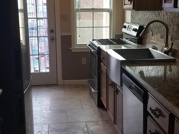 kitchen with tile backsplash, granite counter tops, and stainless steel appliances