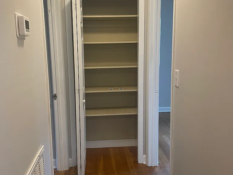 Hallway off living room with a large linen closet on one end, and the bathroom on the other end.