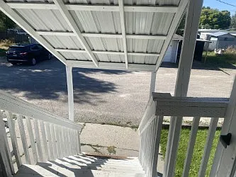 Back entry stairs with carport and parking in back.