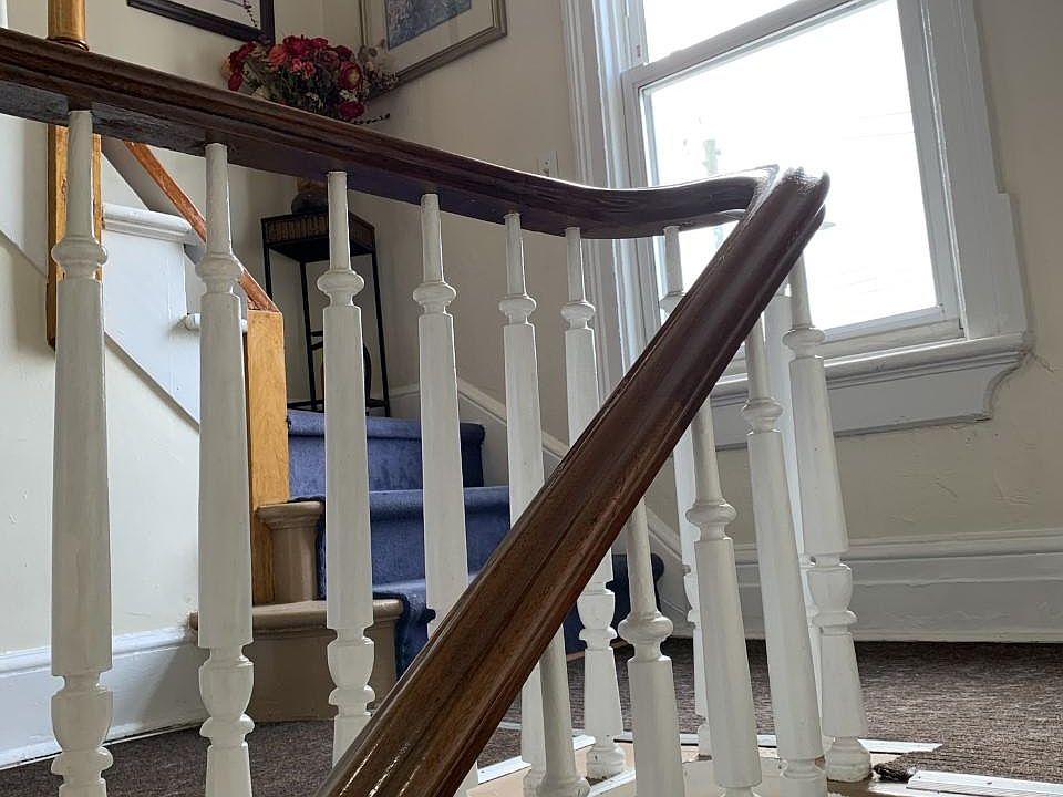 carpeted stairway. decorated with art work and featuring a window for light and to check out the weather before you leave home.