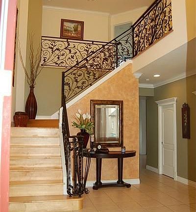 Grand hallway with wrought iron staicase