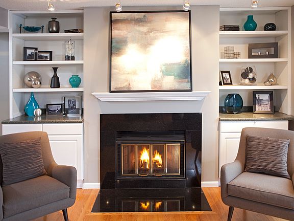 Fireplace w/granite surround & built-in cabinets for decorating & storage