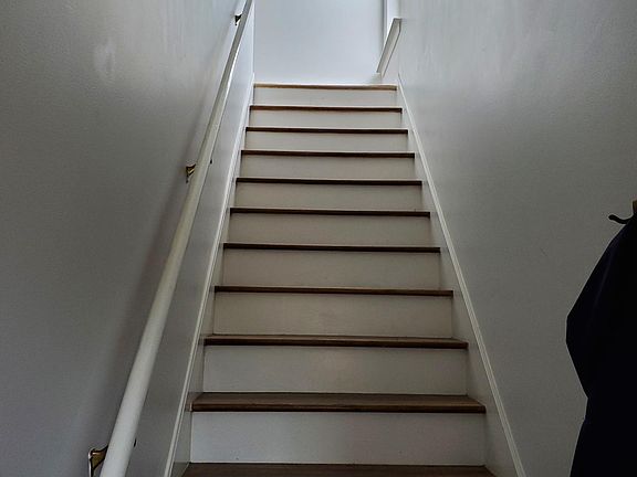 Stairs off the front entrance. Area for coats and shoes