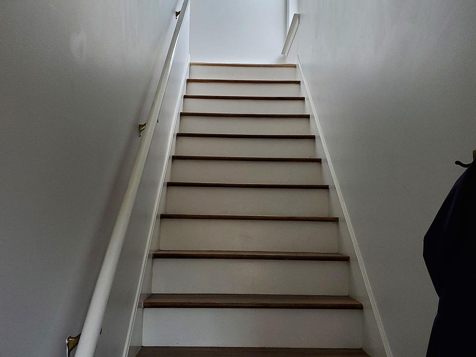 Stairs off the front entrance. Area for coats and shoes
