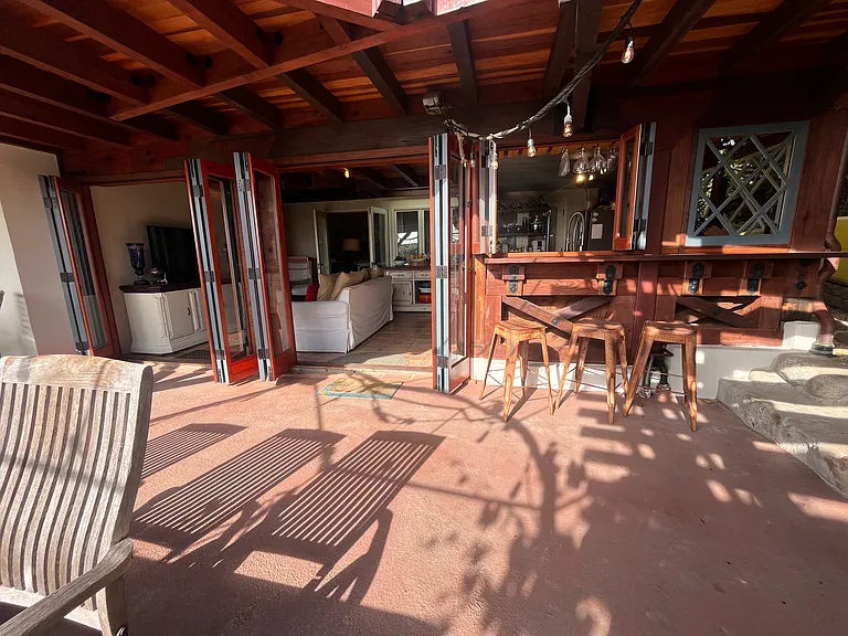 Indoor, Outdoor collapsing doors with bar stools outside the kitchen window for entertaining