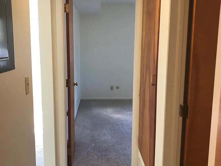 Hallway serving the bedrooms and bathroom. Note the large linen cabinet on the right, and access to your own breaker box to the left.