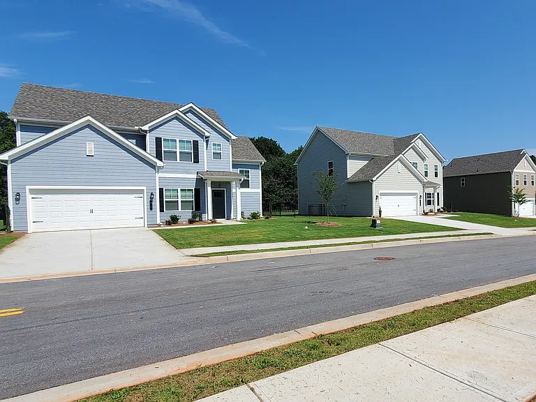 Exterior shot of the two story homes with private driveways and attached garages.
