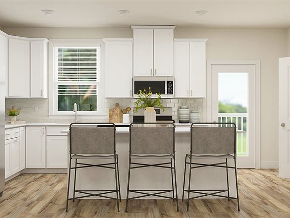 kitchen extends out to deck
kitchen features a center island that doubles as a breakfast bar for casual meals, ample cabinetry room for tucked-away storage and new stainless steel appliances.