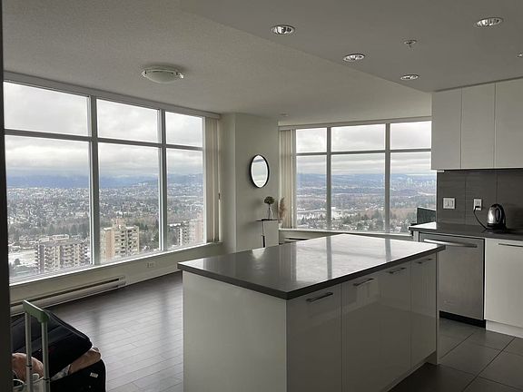 A 275-degree floor-to-ceiling panoramic window offering breathtaking views of the majestic mountains to the north, Downtown, and the serene beauty of Deer Lake to the east.