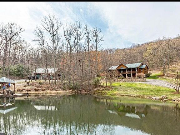House, large detached garage to the left in the picture, spring-fed pond with covered pier