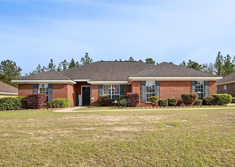 Ranch-style home featuring a front yard and brick siding
