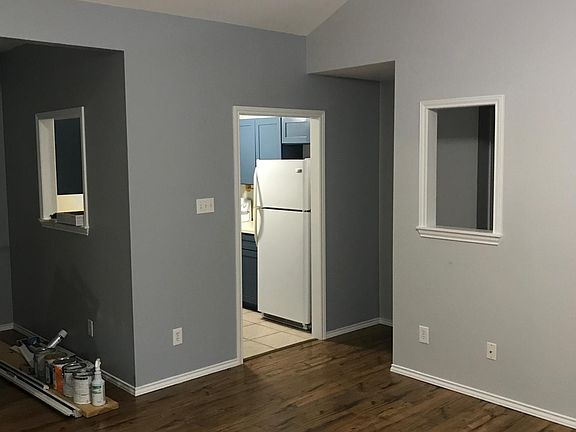 View from living room into kitchen, hallway, and dining area. Classic pass-through windows.