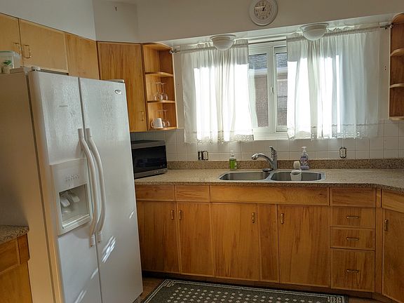 Kitchen with two-basin sink and modern fridge.
