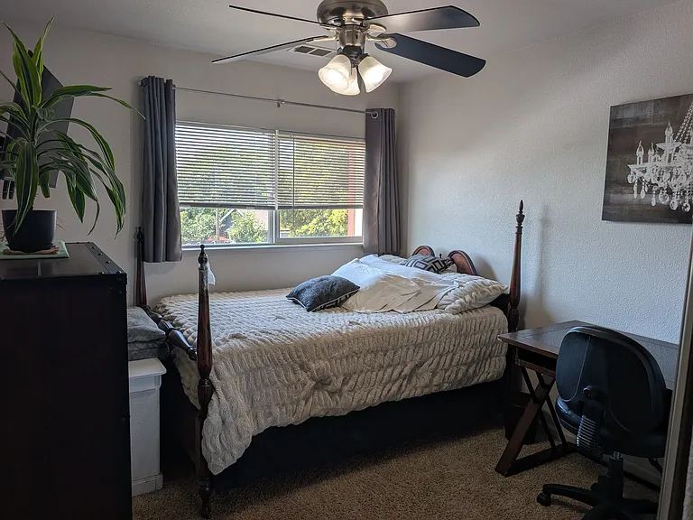 Nice clean bedroom wtih desk/chair, dresser, bed and TV on the wall.