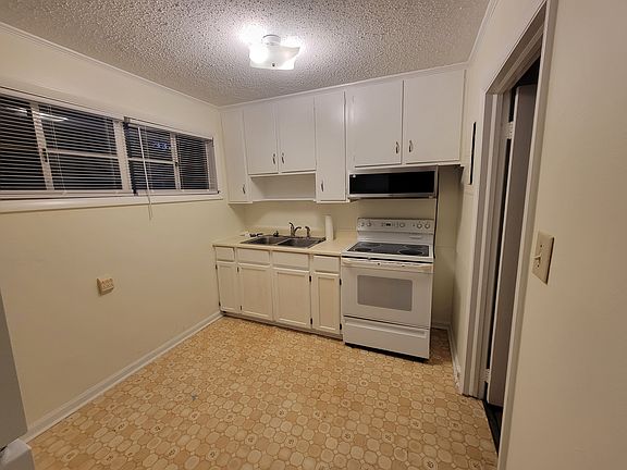 Kitchen with smoothtop stove and over the range microwave