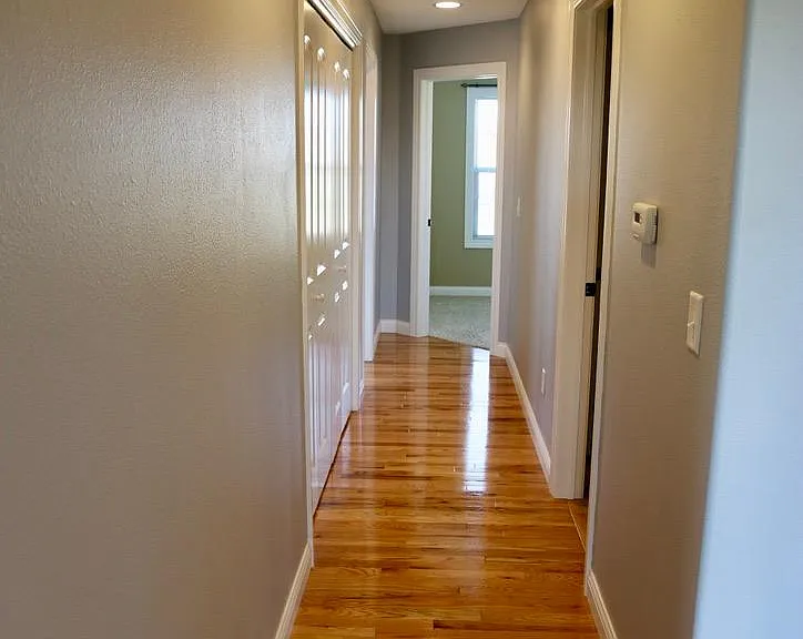 Hallway leading to front bedrooms. Bathroom on right, storage closet on left.
