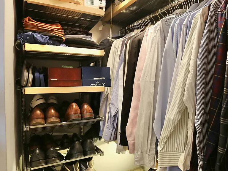 Walk-in closet with Container Store Elfa system and under-shelf lighting.