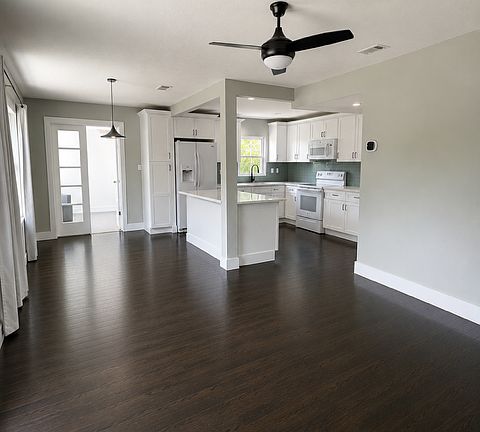 Open-concept living room layout that flows into the kitchen and dining/breakfast area.