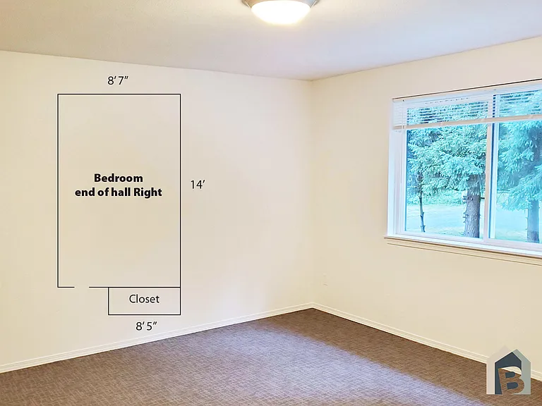 2nd floor large bedroom with view of lawn and mature evergreen trees and double closet