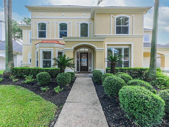 Lush greenery and tropical foliage lend to this lovely curb appeal.