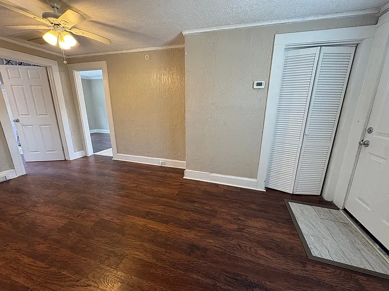 Entry to unit and living room with doors to bed 1 and kitchen/ dining
