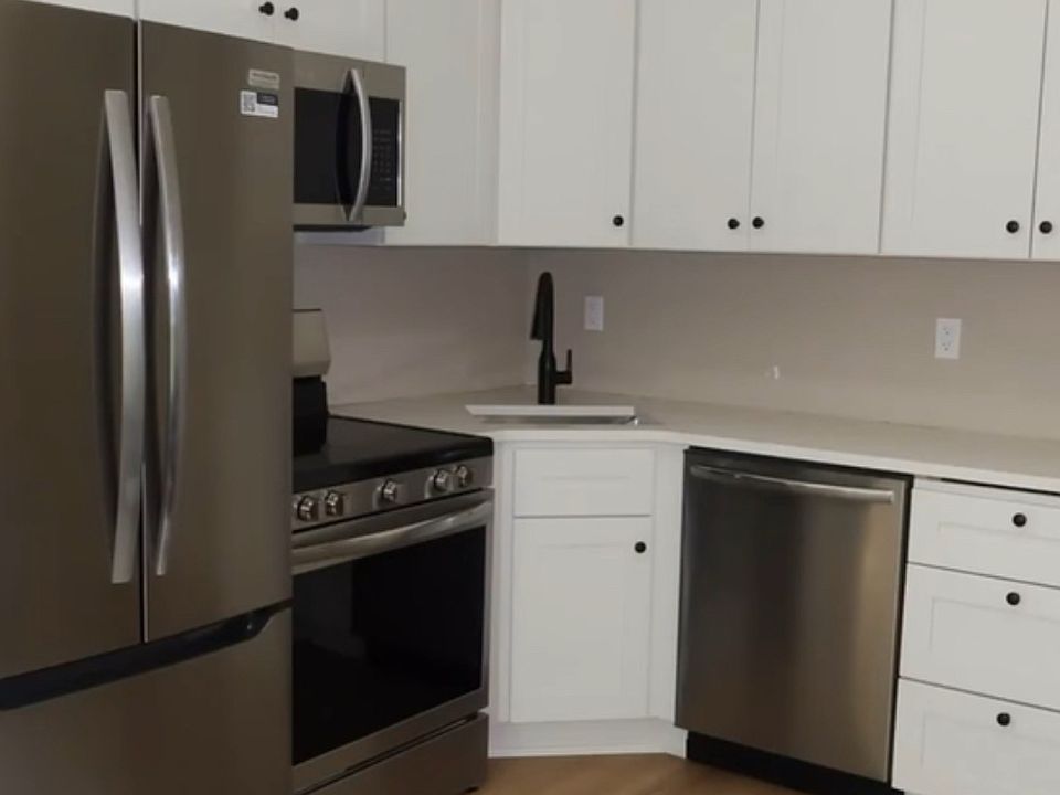 Fully stocked kitchen with dishwasher, utensils, pots and pans.