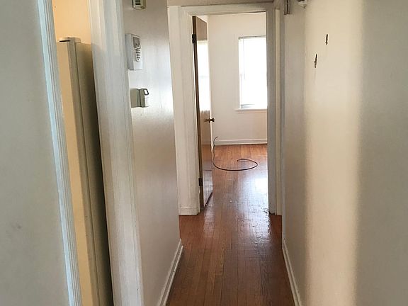 Hallway leading to three bedrooms - all hardwood floors. Also, kitchen on left with almond appliances-stove, refrigerator, dishwasher and microwave. Newly installed maple cabinets with lazy susan