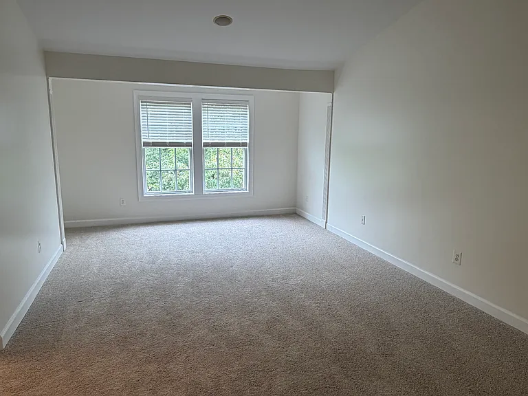 Owner's suite with vaulted ceiling, bathroom and closet on left