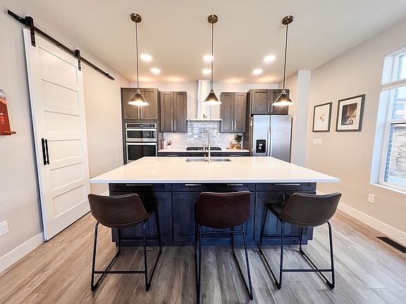 kitchen with large island, gas stove, modern appliances and lots of storage (both sides of the island, pantry and many cabinets)