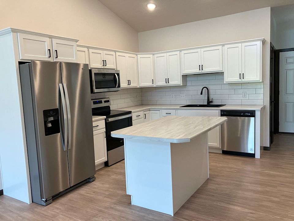 Beautiful White Kitchen. Bright and cheery. There is a pantry with shelving.