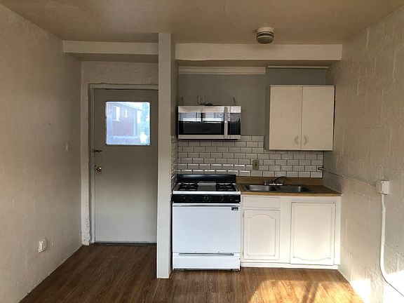 Photograph of the kitchen area located in the room upon entering the apartment. The door to the left of the photo is the entrance to the apartment.